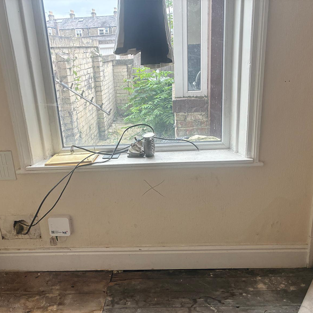 Window bay before treatment — damp damage below sill